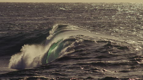 swirling ocean surface churns as wave folds across frame, soft splash and dusk color