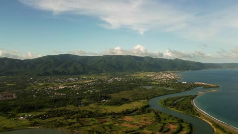 panoramic aerial timelapse of tropical island vista with lush greenery, clouds, and mountainous backdrop - catanduanes, philippines