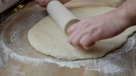 rolling out dough while preparing homemade wheat buns