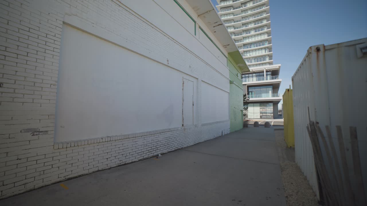 Alleyway with a yellow and a white wall.