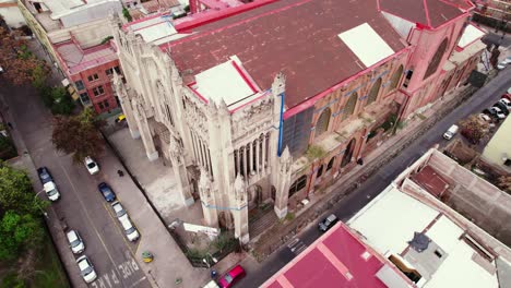 Aerial-orbit-establishing-of-the-worn-and-old-gothic-style-Salvador-Basilica-with-support-and-reinforcements-for-possible-collapses,-Santiago-Chile