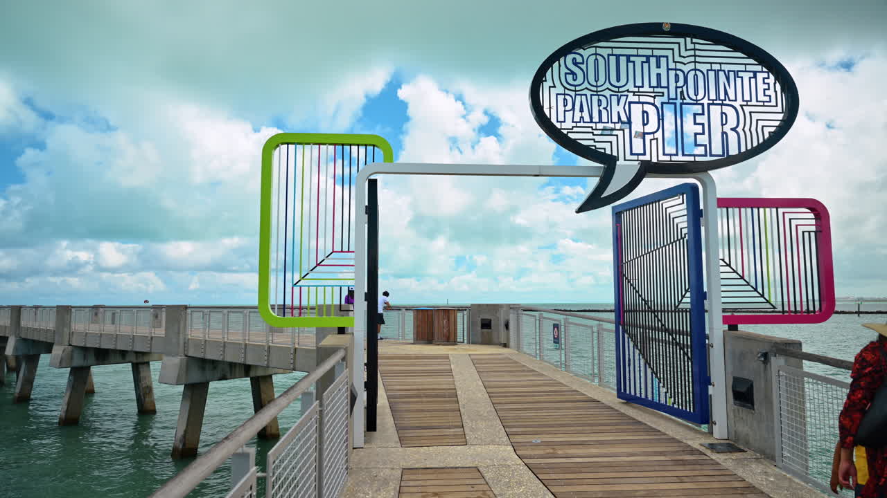 Miami, USA, den 9. april 2026: Indgang til South Pointe Park Pier med farverig port. Trægangbro, der fører til en fiskepier gennem et moderne, farverigt skilt og en port i Miami Beach.