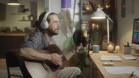 musician recording guitar song in home studio