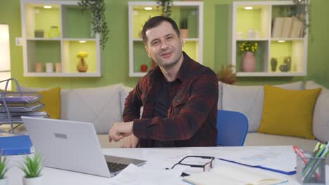 y exitoso y satisfecho trabajador de la oficina en casa mirando a la cámara y sonriendo.
