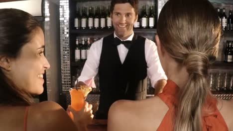 waiter serving cocktail to customers