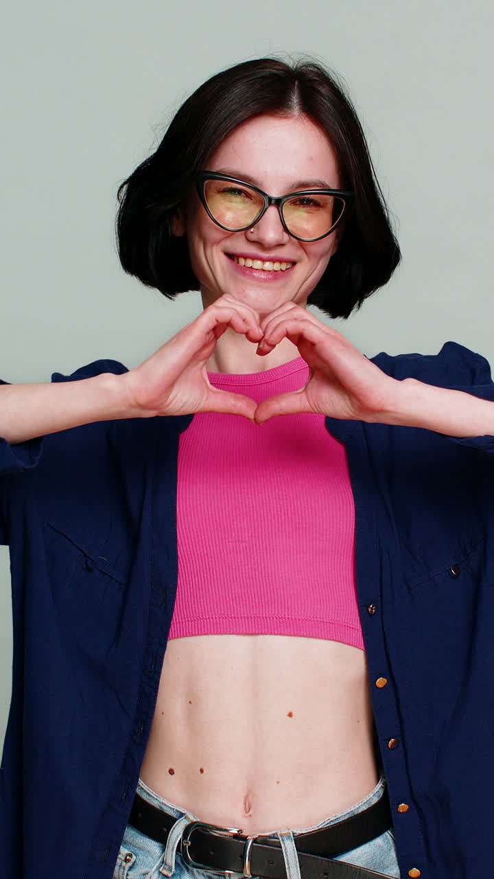 Young woman blowing air kiss towards camera with gentle affectionate smile emotional loving gesture