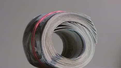 el rollo de billetes de cien dólares está estirado con una banda elástica.