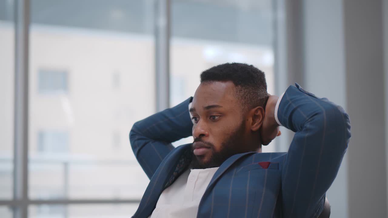 Concentrated african employee sitting at desk waiting for important email