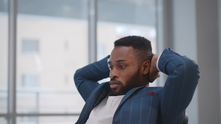 Concentrated african employee sitting at desk waiting for important email