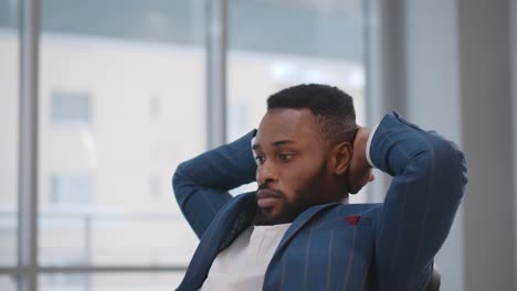 concentrated african employee sitting at desk waiting for important email