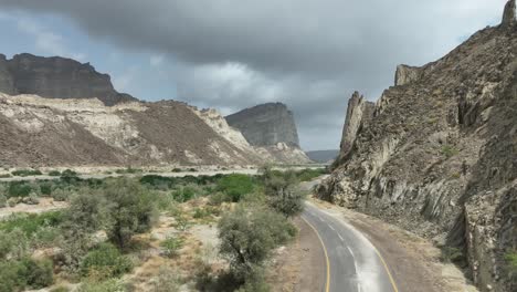 vista aérea de un camión conduciendo por una carretera vacía a través de tierras áridas del desierto en el parque nacional de hingol