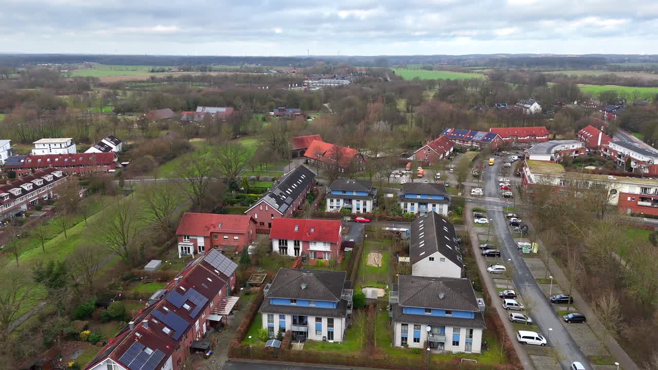 Luxury suburb neighborhood with apartment blocks in German town during winter Season. parking cars .Houses with solar panels in scenic area. Aerial wide shot.