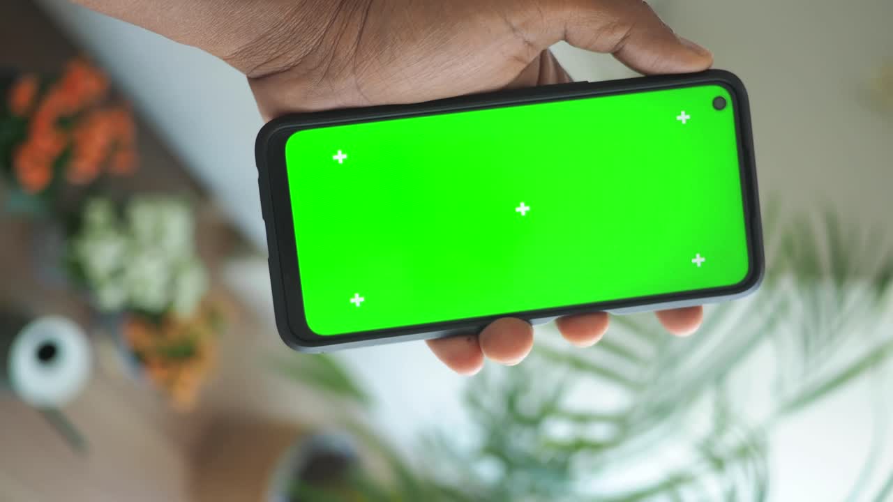 teléfono inteligente en la mano con pantalla verde