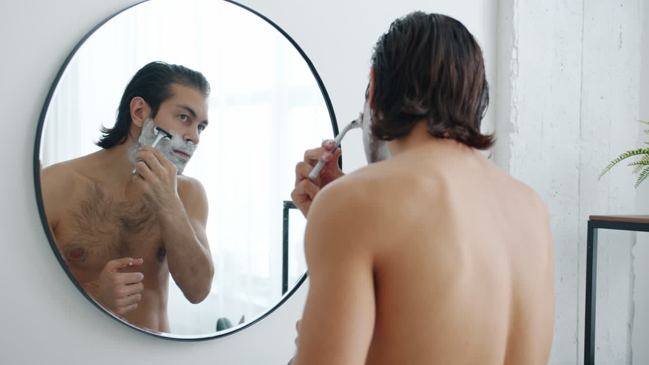 Man shaving in front of a mirror