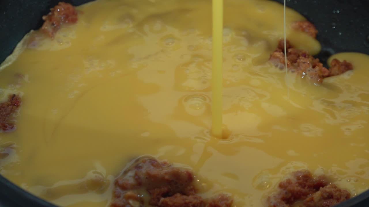 algunos chorizo con huevos revueltos cocinados en una sartén