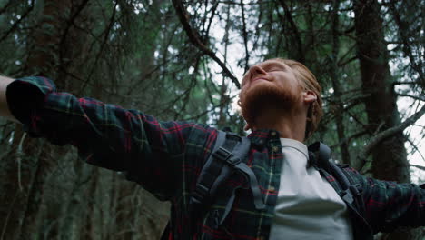 satisfied guy taking rest during hike in woods. male tourist enjoying nature