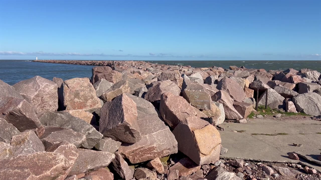 Vista statica di grandi rocce e sentiero pavimentato all'estremità del frangiflutti a Rio Grande, Brasile