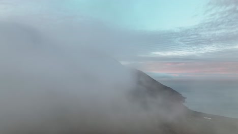 mountains covered in clouds in borgarfjordur eystri, iceland - aerial drone shot