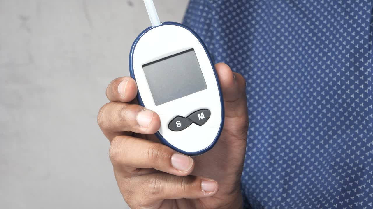 Person holding a blood glucose meter