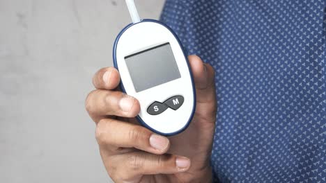 person holding a blood glucose meter