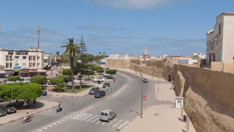 Traffic-on-road-outside-fortified-city-of-mazagan,-wide-shot