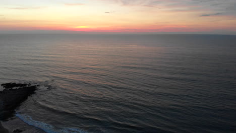 Aerial-approaching-sunset-over-sea-in-La-Union,-Philippines