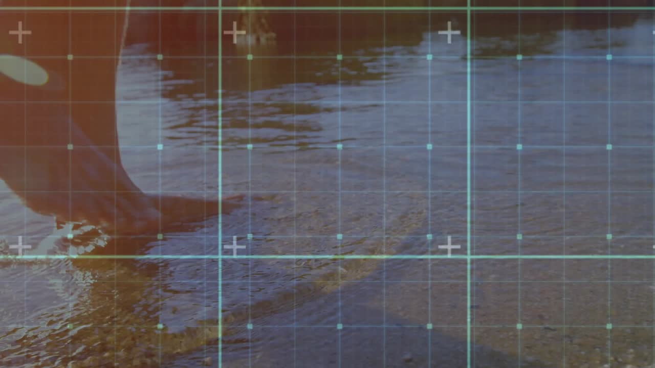Once waves lapping man stepping through shoreline under translucent tech grid animating ripples