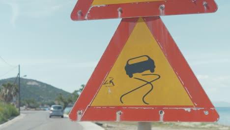 Slippery-road-sign-warning-on-dangerous-road