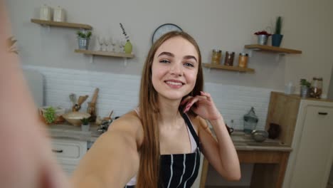 pov shot of blogger girl making photos, taking selfies for social media on mobile phone at kitchen