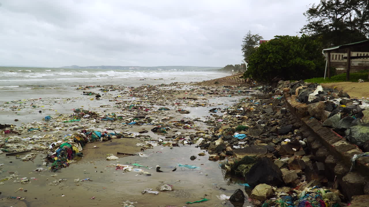 Beach polluted by garbage trash on a gloomy overcast day
