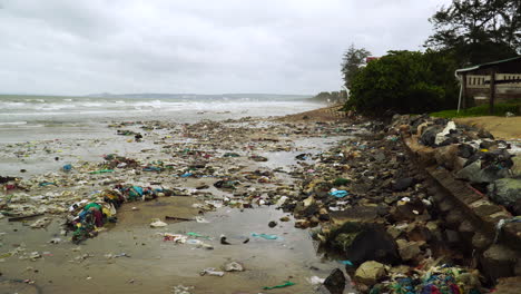 Beach polluted by garbage trash on a gloomy overcast day
