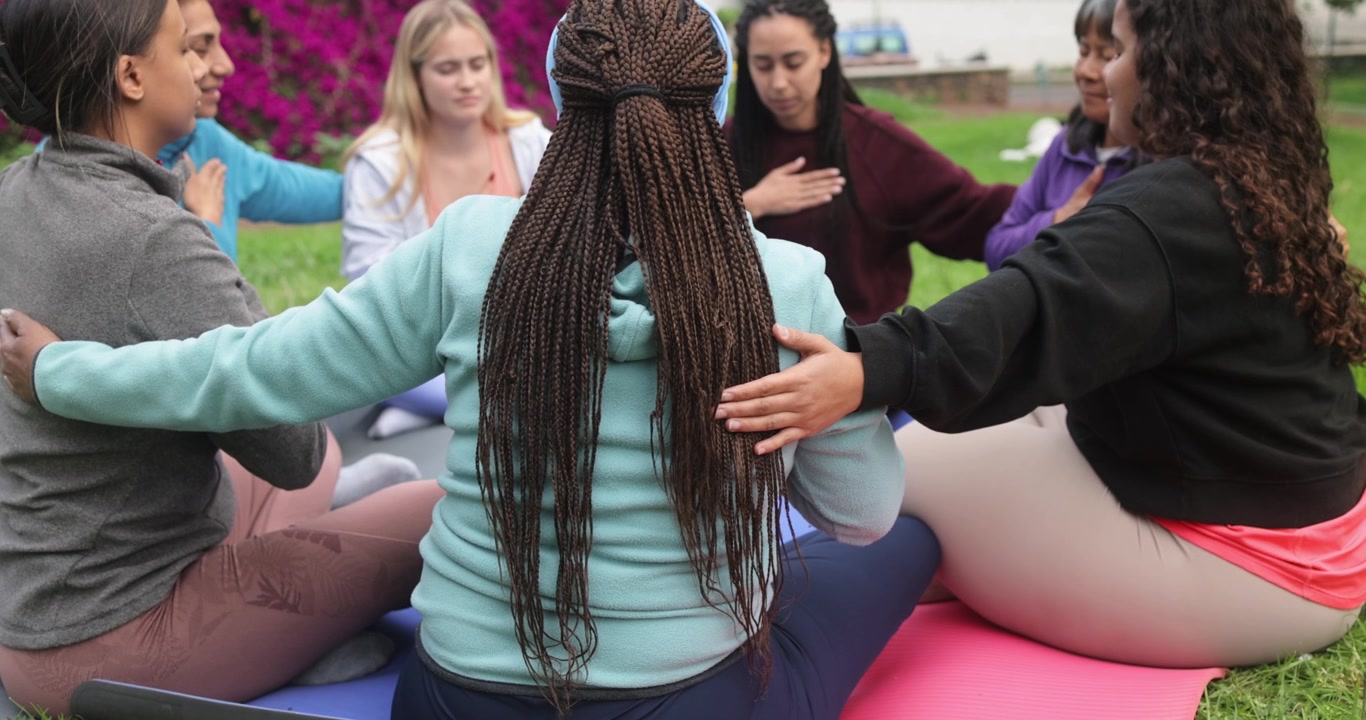 Grupo diversificado de mulheres praticando ioga juntas ao ar livre