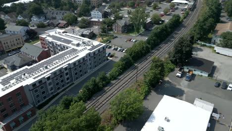 Luftwagen-Neigen-Sich-über-Bahngleise-Und-Wohngebäude-Mit-Sonnenkollektoren,-Northampton,-Massachusetts