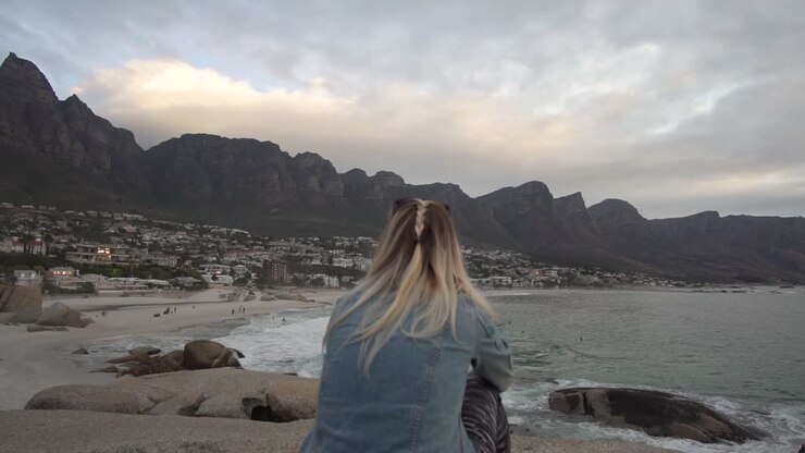 Ragazza che guarda la costa di Camps Bay a Città del Capo con la Table Mountain sullo sfondo al rallentatore