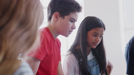 Grupo-De-Estudiantes-En-Clase-Trabajando-Con-Profesores-Masculinos-Y-Femeninos