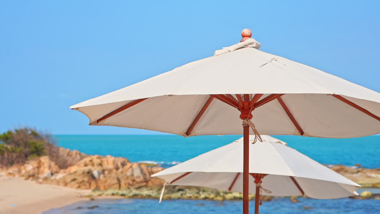 cerca de sombrillas de playa, sombrillas y mar tropical en la brisa de verano