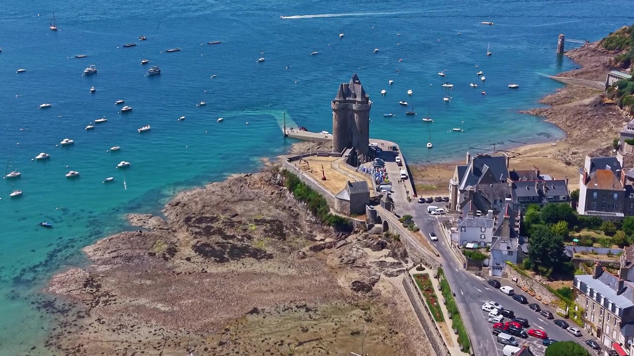 Luftfoto af det historiske stentårn Tour Solidor ved en turkis bugt med både og nærliggende landsbygader