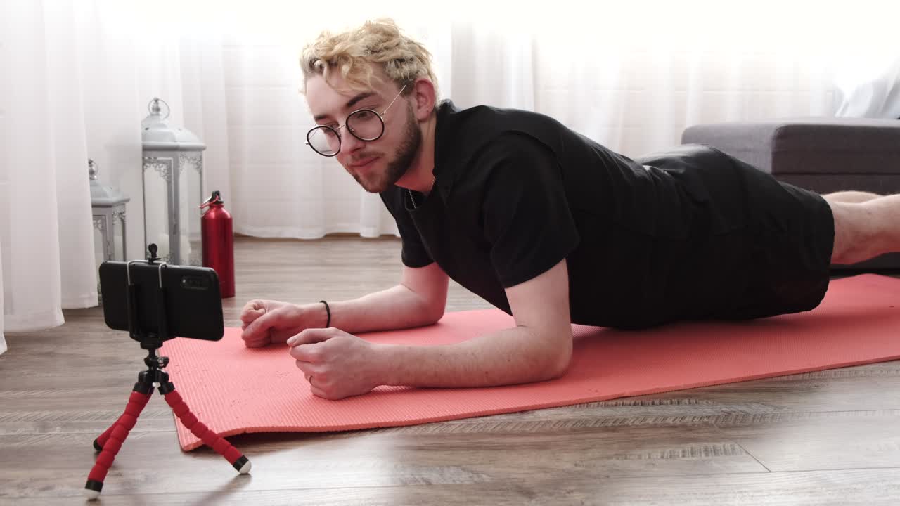 joven deportivo filmando el ejercicio matutino en la cámara