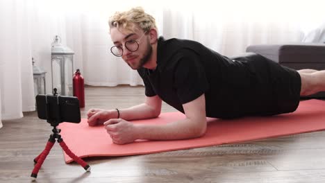 young sporty man filming morning exercise on camera