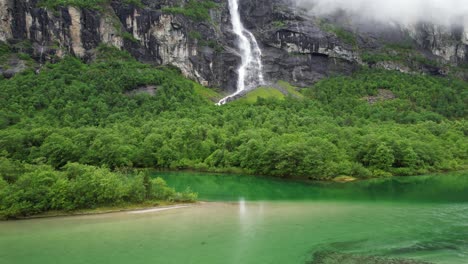 wasserfall und grüner see in den bergen norwegens