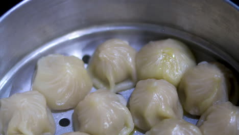 cinematic pan of homemade momo dumplings in a steamer