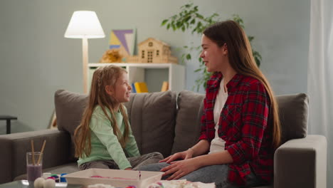 la hermana mayor discute con la niña el color de los huevos de pascua