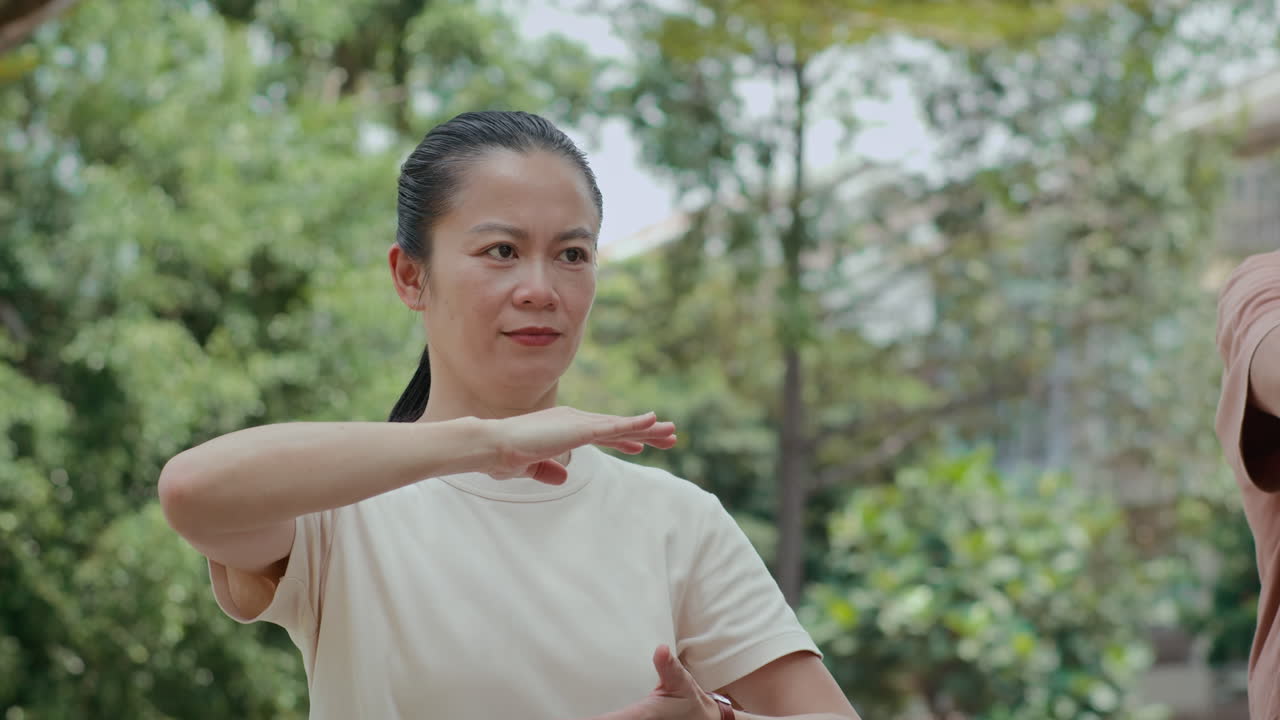 Active Middle-aged Woman Performing Tai Chi Moves in Park