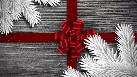 Video-composition-with-snow-over-Christmas-gift-ornaments-on-wood