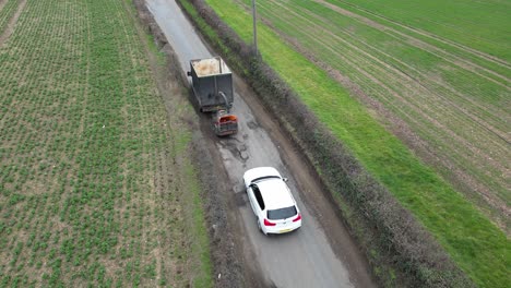 lorry towing trailer drives over large potholes on uk roads overhead birds eye view drone aerial