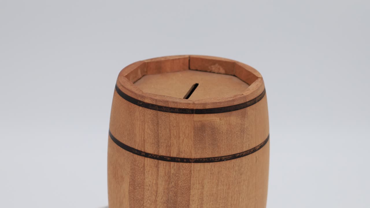 Wooden barrel-shaped money box rotates clockwise
