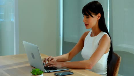 Ejecutiva-Femenina-Usando-Computadora-Portátil-Y-Teléfono-Móvil