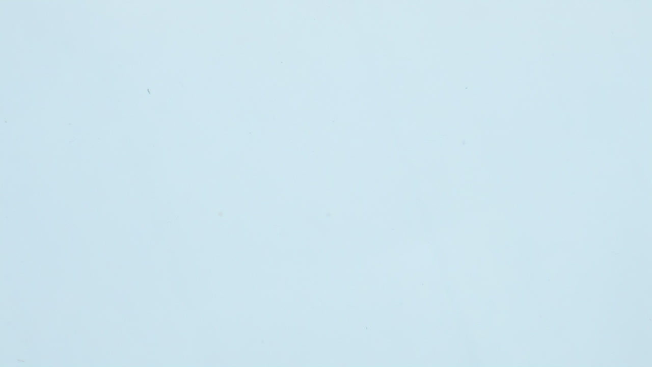 un pedazo de cítrico sumergiendo agua con burbujas de cerca. una rodaja de lima cayendo bajo el agua.