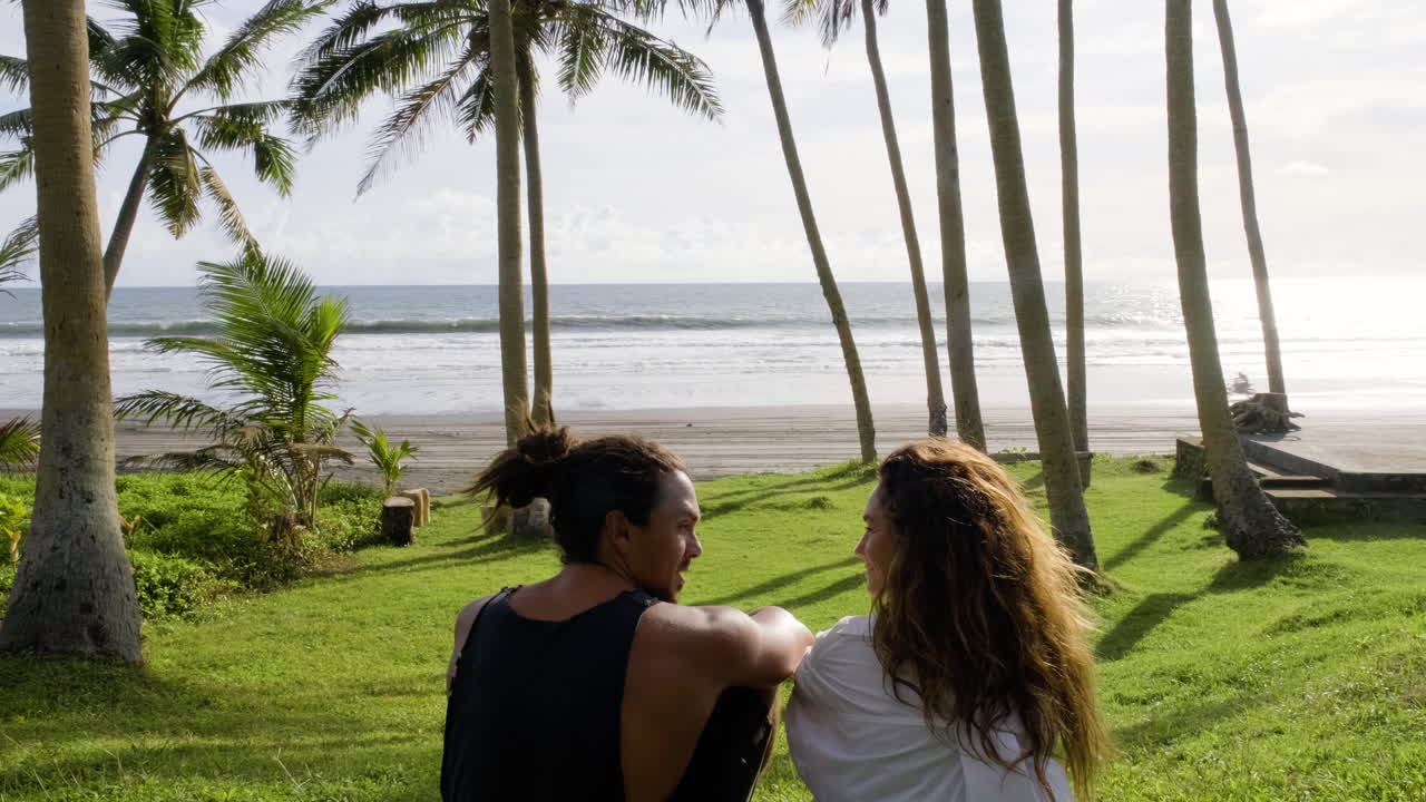 풀밭에 앉아 있는 젊은 부부