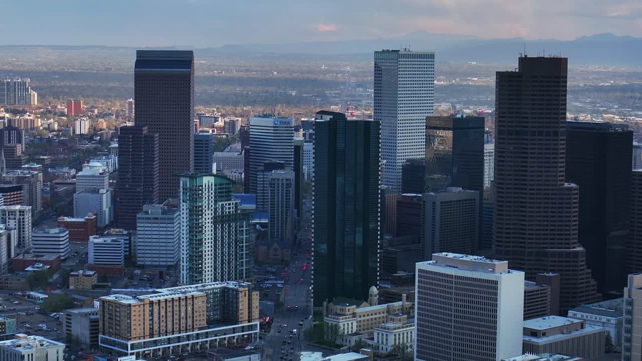 Downtown Denver cityscape city tall skyscraper buildings aerial drone Colorado spring summer afternoon sunset mountains range landscape City Park Rhino pan clouds sunny panorama upwards motion